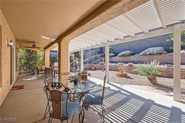 view of patio with a ceiling fan, fence, outdoor dining area, and a pergola