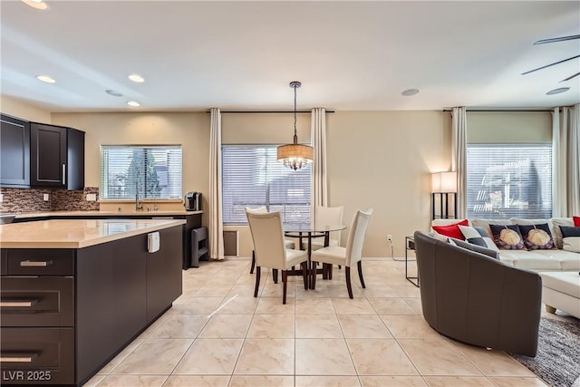 kitchen featuring decorative light fixtures, light tile patterned floors, tasteful backsplash, light countertops, and open floor plan