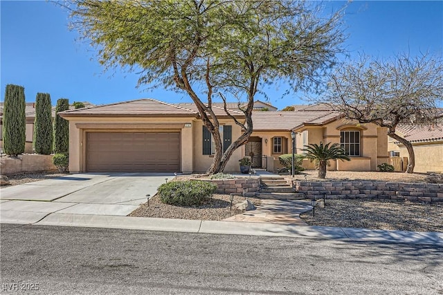 view of front facade featuring driveway, an attached garage, a tiled roof, and stucco siding