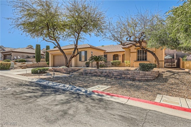 view of front of property featuring a garage, fence, driveway, and stucco siding