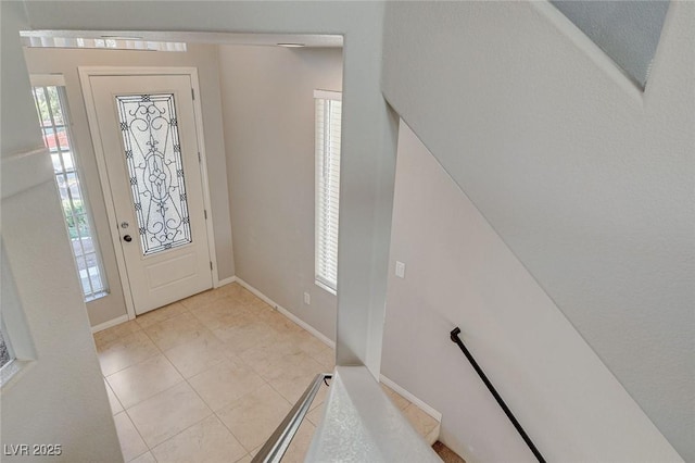 foyer with light tile patterned flooring and baseboards