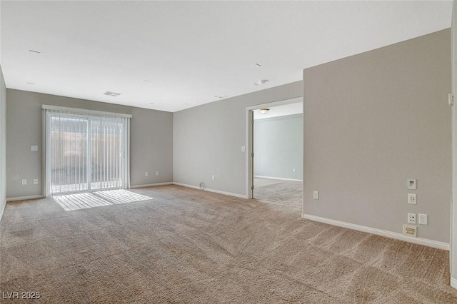 spare room featuring light carpet, visible vents, and baseboards