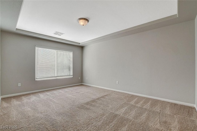 spare room featuring carpet floors, visible vents, and baseboards