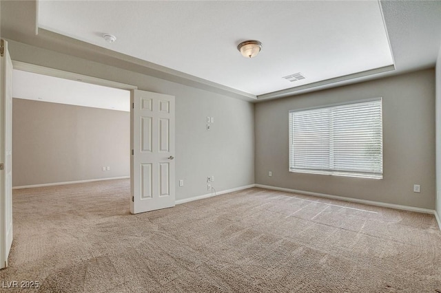 spare room featuring carpet, visible vents, and baseboards