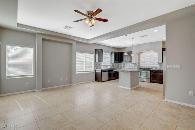 kitchen with light tile patterned floors, visible vents, stainless steel appliances, and decorative backsplash