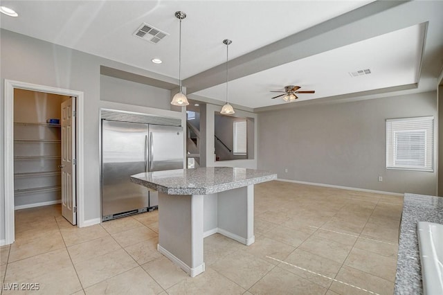 kitchen featuring light tile patterned floors, baseboards, visible vents, and built in fridge