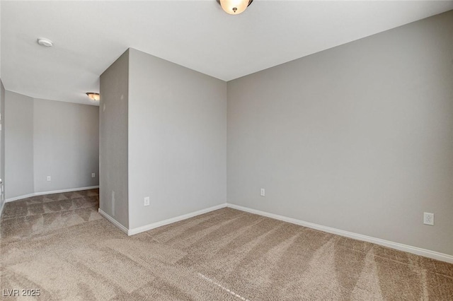 carpeted spare room featuring baseboards