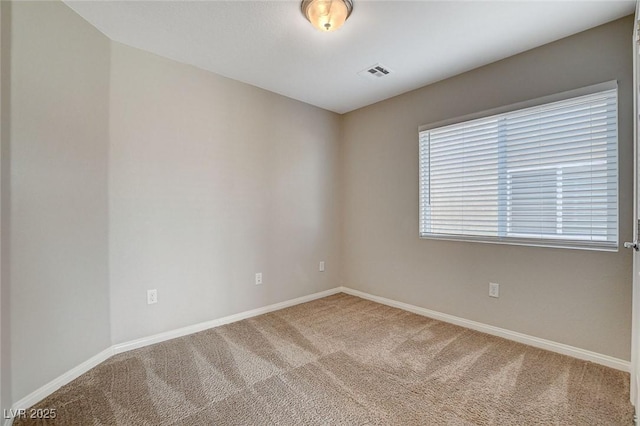 carpeted empty room with visible vents and baseboards