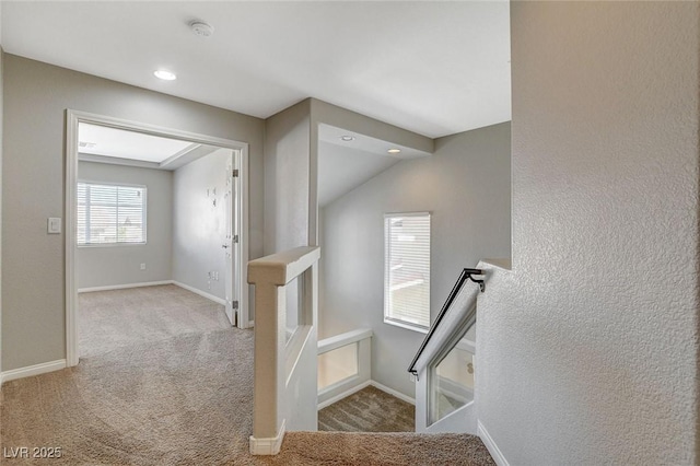 staircase featuring carpet floors and baseboards