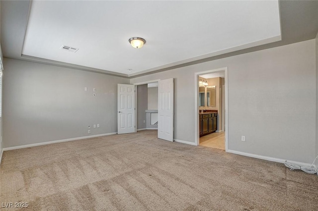 unfurnished bedroom with visible vents, connected bathroom, light carpet, and baseboards