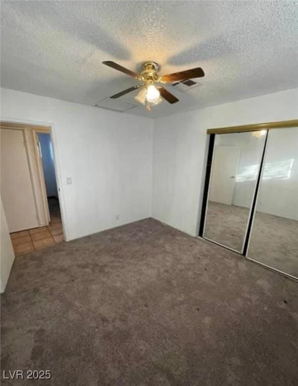 unfurnished bedroom with carpet floors, a textured ceiling, visible vents, and a closet