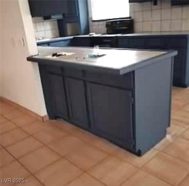 kitchen with light tile patterned floors, backsplash, and baseboards