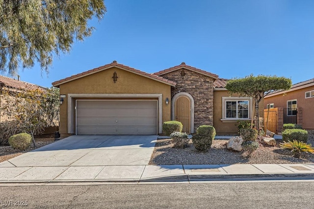 view of front of property featuring an attached garage, stone siding, concrete driveway, a tiled roof, and stucco siding