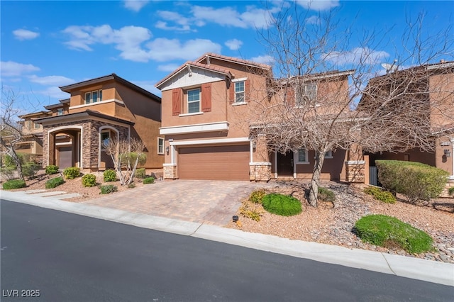 view of front of house with decorative driveway, stone siding, a garage, and stucco siding