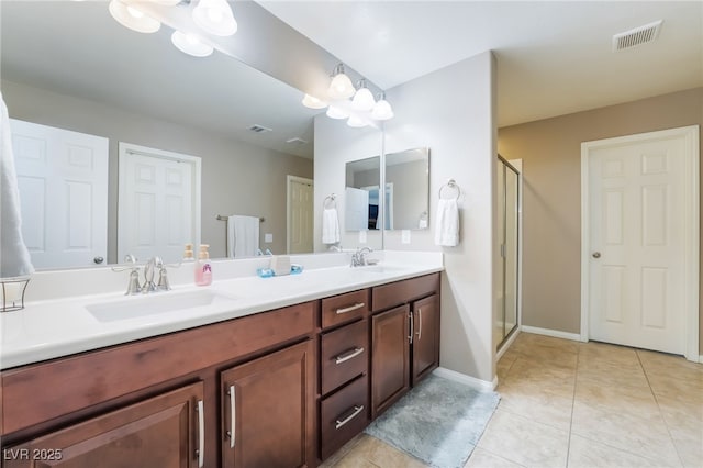 full bath with a stall shower, tile patterned flooring, visible vents, and a sink