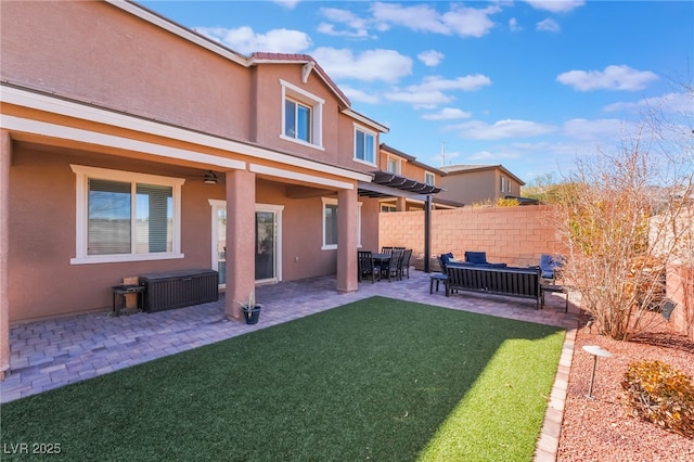 back of house featuring a lawn, fence, a patio, and stucco siding