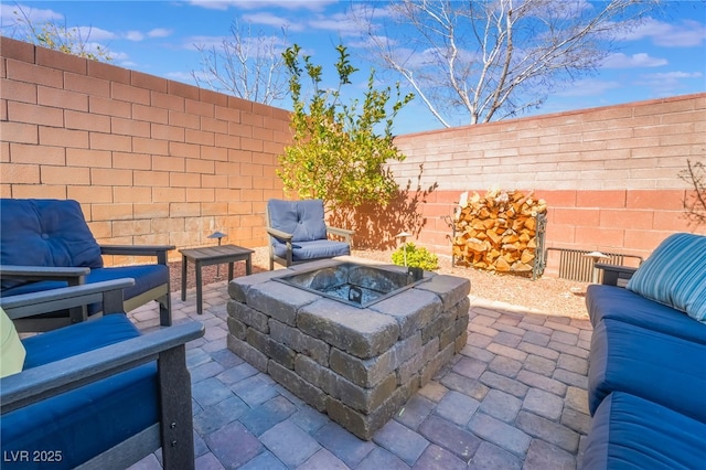 view of patio with an outdoor living space with a fire pit and a fenced backyard