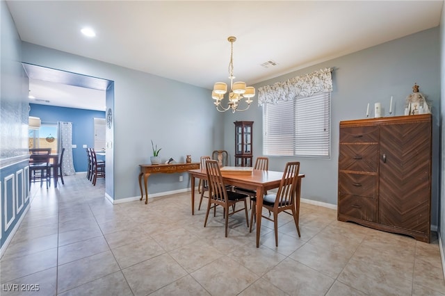 dining room featuring a chandelier, light tile patterned flooring, visible vents, and baseboards