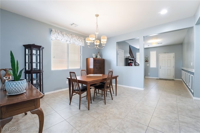 dining area with an inviting chandelier, visible vents, light tile patterned floors, and baseboards