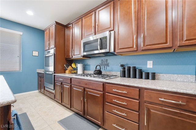 kitchen with stainless steel appliances, light countertops, baseboards, and light tile patterned flooring