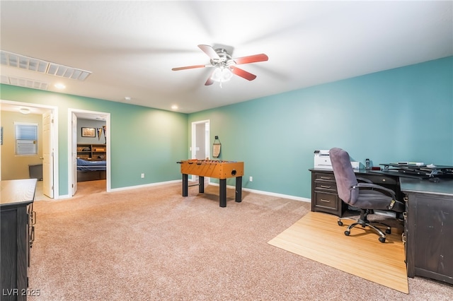 office space with light colored carpet, ceiling fan, visible vents, and baseboards