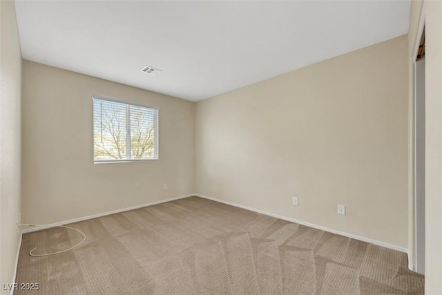 spare room featuring carpet and baseboards