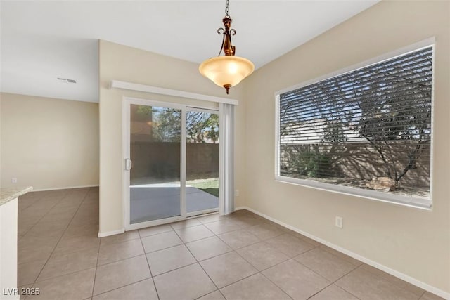 unfurnished dining area featuring visible vents, baseboards, and light tile patterned flooring