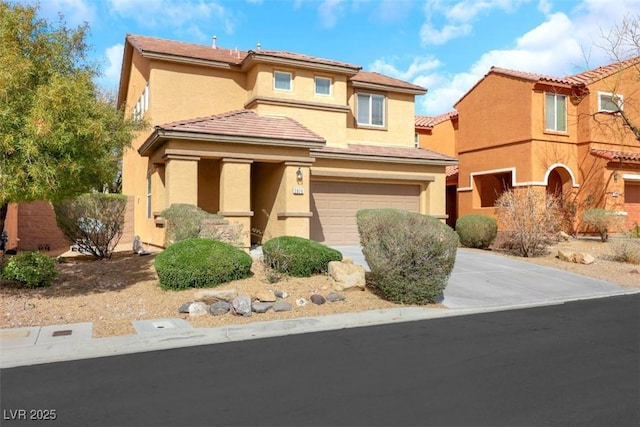 view of front of home featuring a garage, concrete driveway, and stucco siding