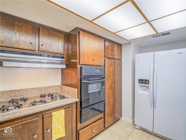 kitchen with oven, under cabinet range hood, white fridge with ice dispenser, stainless steel gas cooktop, and a warming drawer