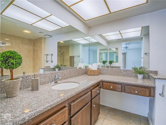 full bathroom with a skylight, visible vents, vanity, tile patterned flooring, and tiled shower