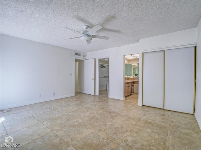 unfurnished bedroom featuring baseboards, visible vents, connected bathroom, ceiling fan, and a textured ceiling