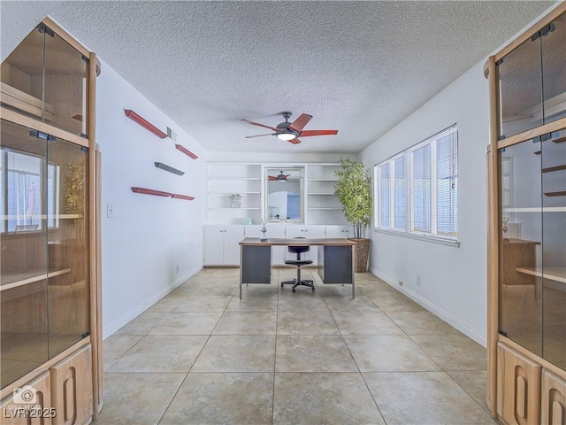 office with light tile patterned floors, baseboards, a ceiling fan, and a textured ceiling