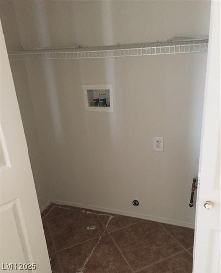 laundry area featuring washer hookup, laundry area, dark tile patterned floors, and baseboards