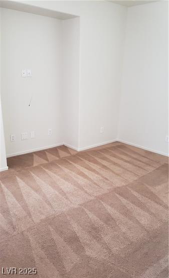 unfurnished room featuring carpet and baseboards