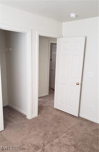 unfurnished bedroom with carpet floors, a spacious closet, and a closet