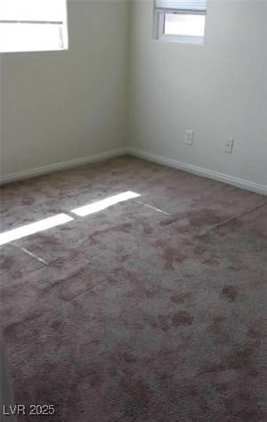 spare room featuring carpet floors and baseboards