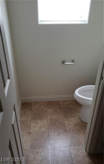 bathroom with toilet, tile patterned flooring, and baseboards