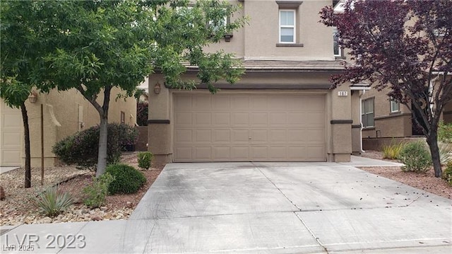 view of front facade with concrete driveway and stucco siding