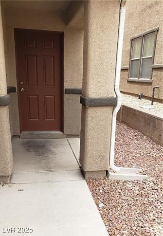 entrance to property featuring stucco siding