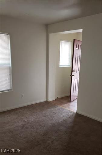 unfurnished room with carpet and baseboards