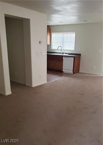 kitchen with carpet, white dishwasher, baseboards, and brown cabinetry