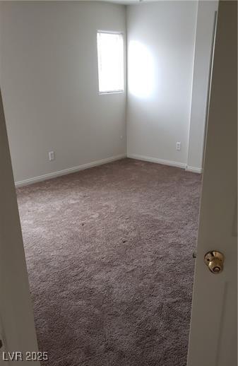 unfurnished room with carpet flooring and baseboards