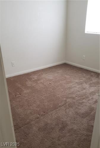 empty room featuring carpet floors and baseboards