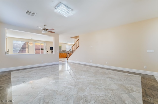 spare room with marble finish floor, visible vents, a ceiling fan, baseboards, and stairs