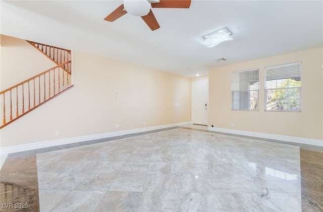 spare room with visible vents, baseboards, ceiling fan, stairway, and marble finish floor