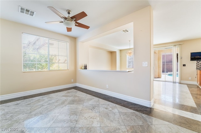 empty room with a ceiling fan, visible vents, and baseboards