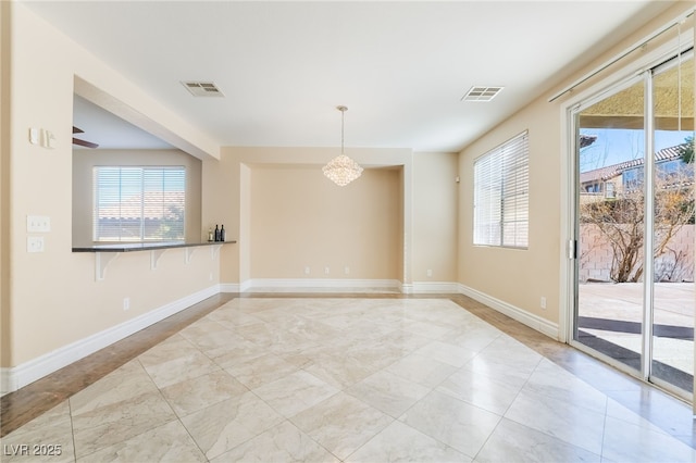 spare room featuring visible vents, plenty of natural light, and baseboards