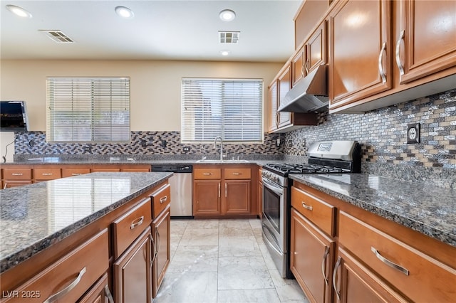 kitchen with under cabinet range hood, stainless steel appliances, a sink, visible vents, and brown cabinets