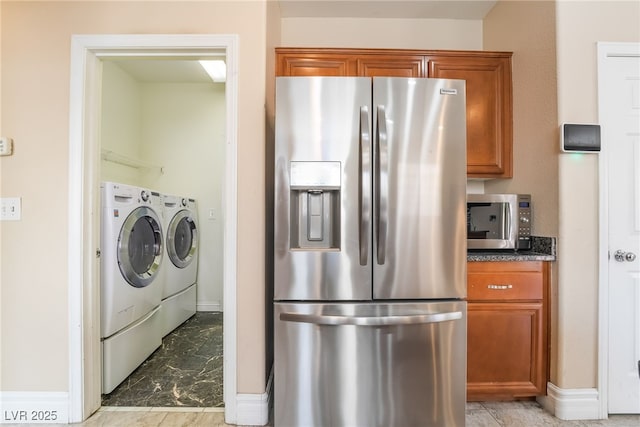 kitchen featuring marble finish floor, stainless steel appliances, washer and clothes dryer, and brown cabinets