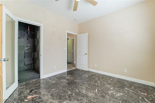 unfurnished bedroom with marble finish floor, baseboards, and a ceiling fan